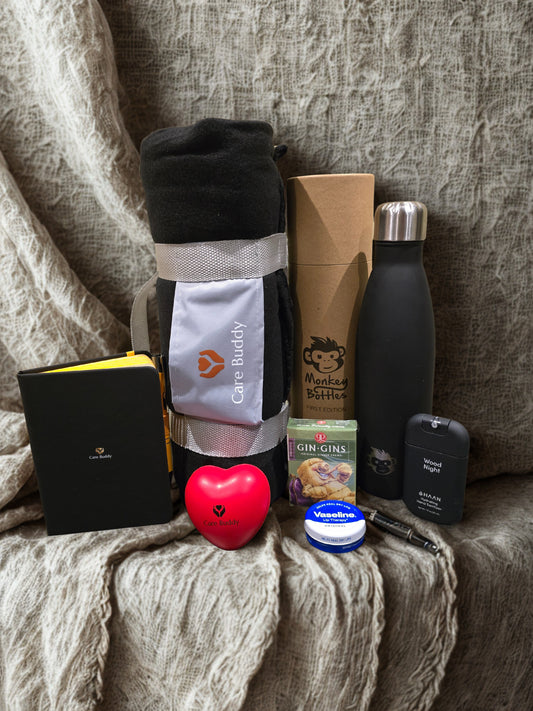 Essential Chemo Package for Him containing cosy Fleece black blanket that rolls up into a holder, Monkey Bottle colour Black keeps drinks Cold 24hrs and Warm for 12hrs. Black Journal and Yellow Pen. Red Heart shaped Stress Ball. Gin Gin chews for Nausea. Vaseline Lip Balm. Haan Hydrating spray Hand Sanitizer