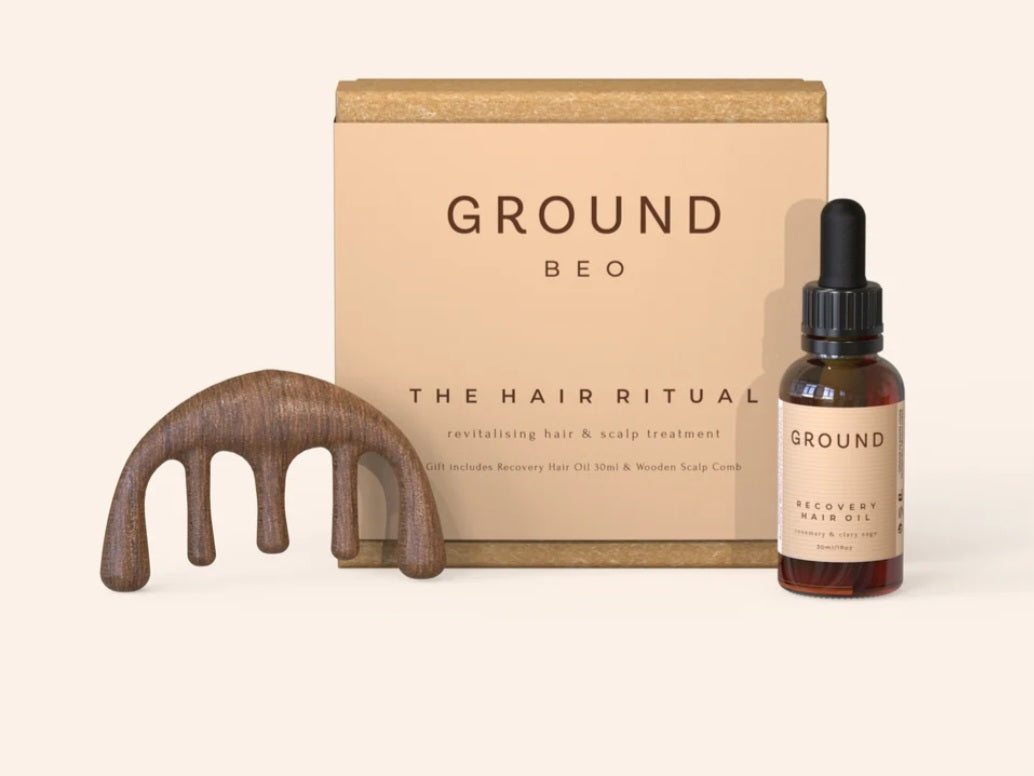 A hair and scalp treatment gift set featuring a wooden massaging comb and a 30ml dropper bottle of Recovery Hair Oil