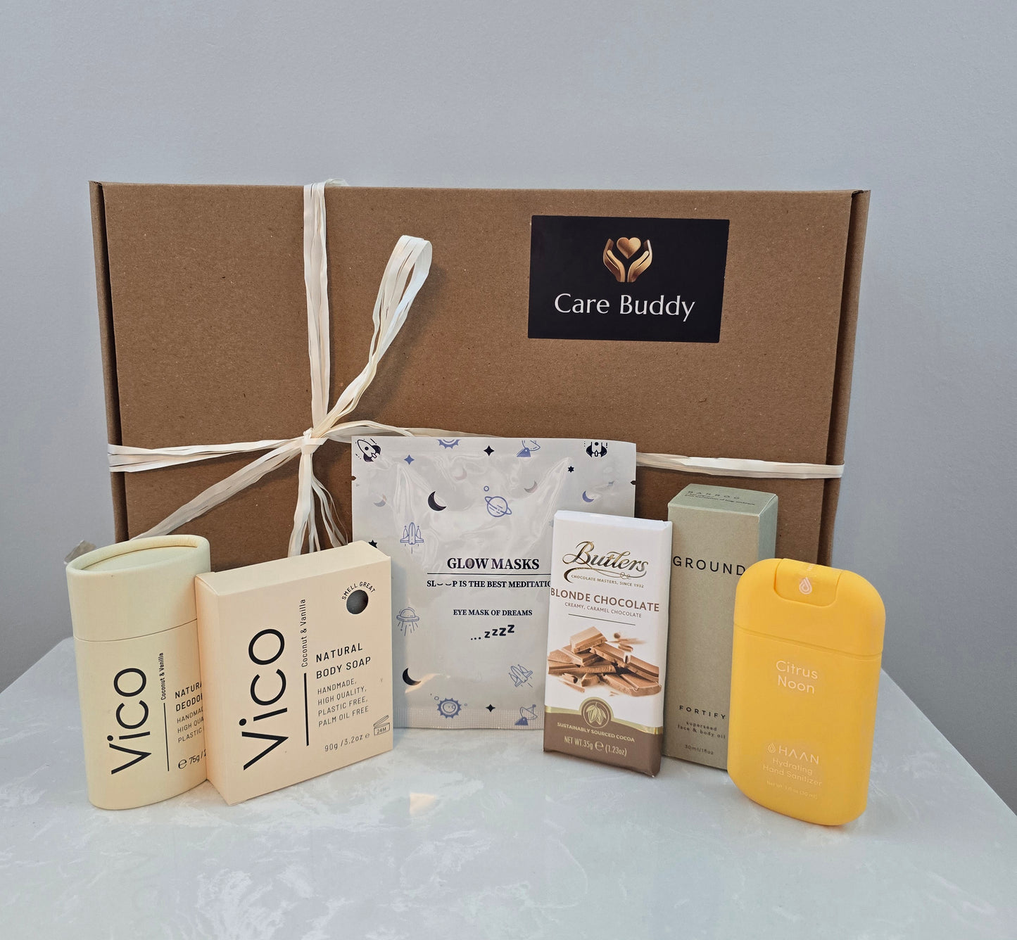Care Buddy box with Vico natural Deodrant and Body Soap. Glow Mask. Butlers Choc bar. Haan Hydrating Sanitizer and Ground Wellbeing Face & Body oil