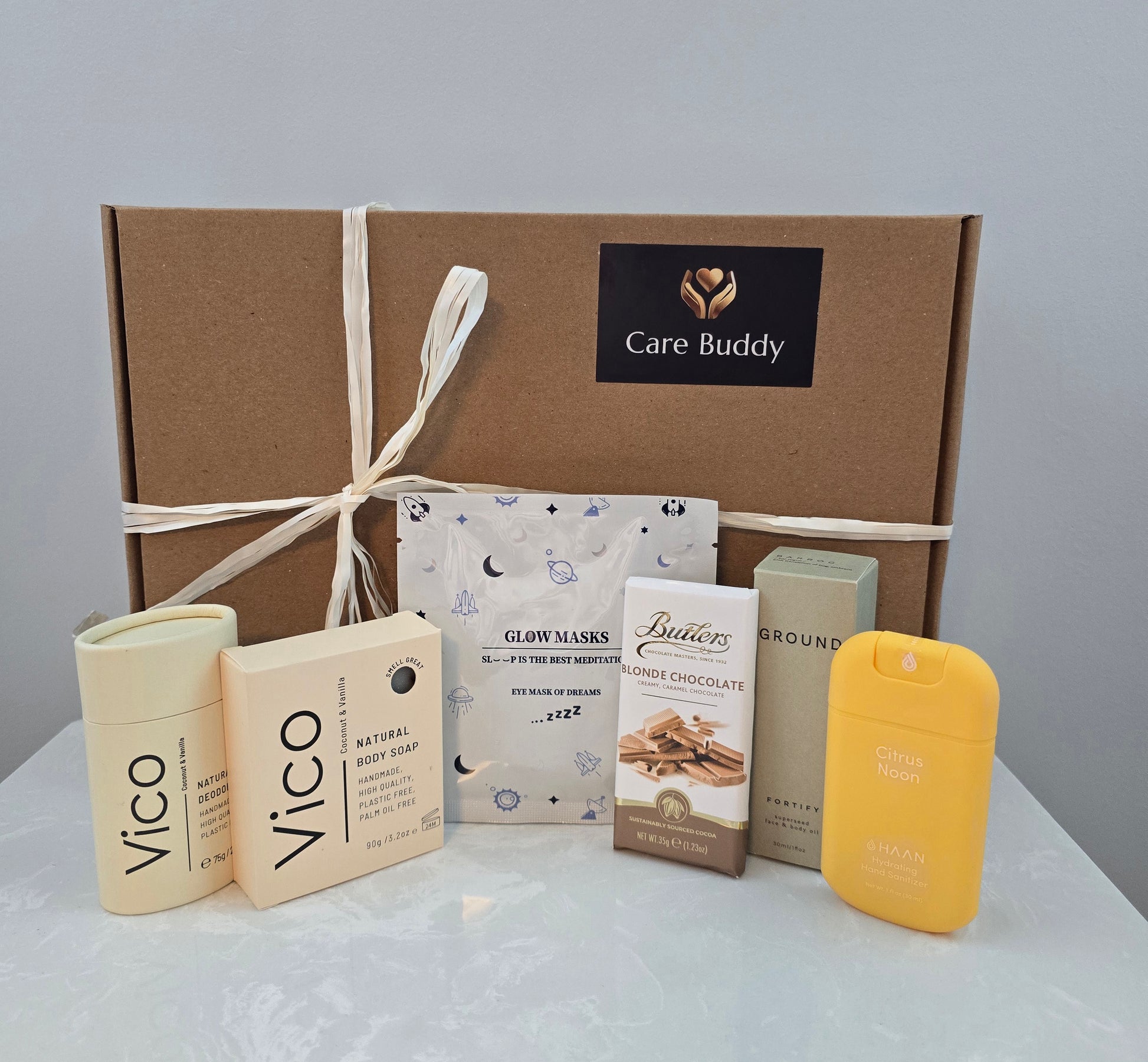 Care Buddy box with Vico natural Deodrant and Body Soap. Glow Mask. Butlers Choc bar. Haan Hydrating Sanitizer and Ground Wellbeing Face & Body oil
